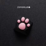 Close-up angled view of the ZOMOPLUS black-pink kitty paw keycap, highlighting the soft, bouncy paw pads and strong ABS construction.