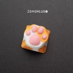 Close-up of ZOMOPLUS kitty paw artisan keycap in orange cat design, showcasing playful charm for keyboard and cat lovers.