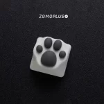 ZOMOPLUS white-grey kitty paw keycap in a slanted view, showing off its unique paw design and tactile feel.