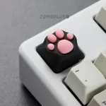 ZOMOPLUS kitty paw artisan keycap with soft silicone installed on a keyboard, highlighting its bouncy feel and cute black-pink color scheme.