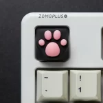 Top view of the ZOMOPLUS black-pink kitty paw artisan keycap, installed on a keyboard, emphasizing soft paw pads and ABS base.