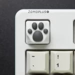 Overhead view of the ZOMOPLUS white-grey kitty paw keycap installed on a mechanical keyboard, adding a fun and playful look to the workspace.