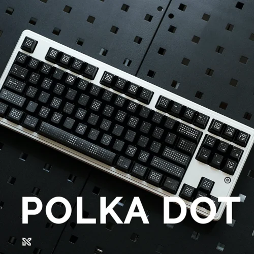 Complete mechanical keyboard with black polka dot keycaps installed, white keyboard frame, professional gaming setup